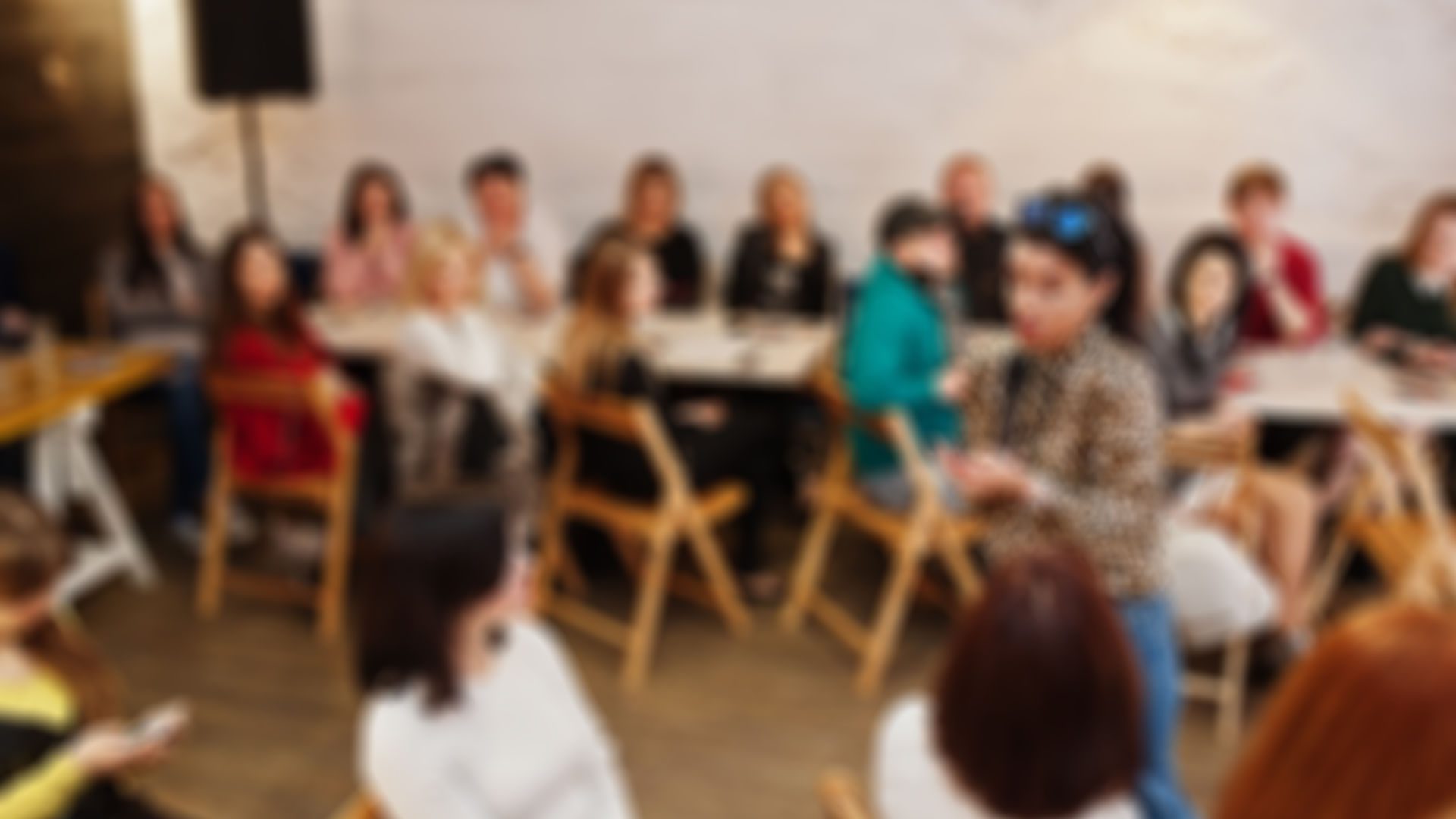 Abstract blurred photo of conference or seminar room with speaker on the stage.